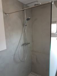 Een strakke douche met een micro betonnen wandafwerking.